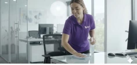 Helpi cleaner wiping an office desk